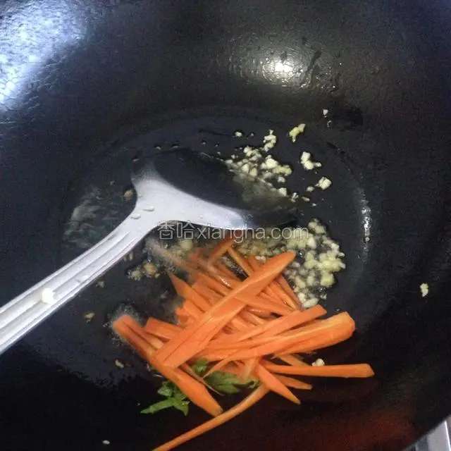 锅中放适量的油爆香蒜末，下入胡萝卜偏炒软