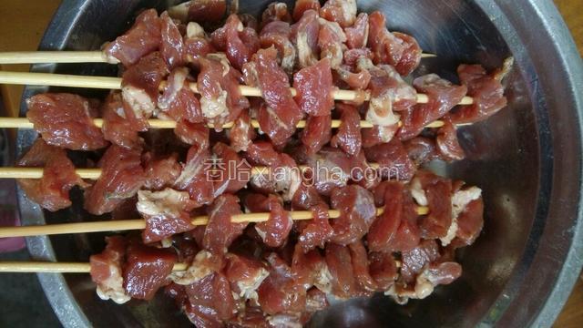 将羊肉串到竹签上，刷上一层油