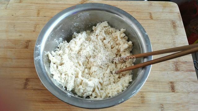 将面粉放入盆中，加适量色拉油和盐，慢慢加水搅拌成棉絮状