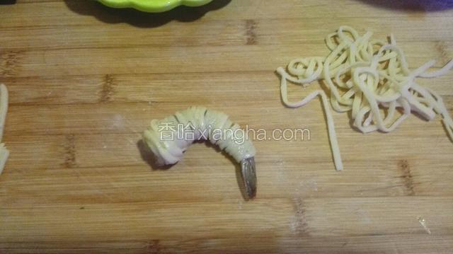 将虾取出，用面条将虾裹住