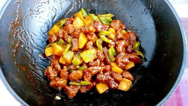放入炸好的肉块和青椒改大火快速翻炒，使肉块均匀的裹上酱汁即可。