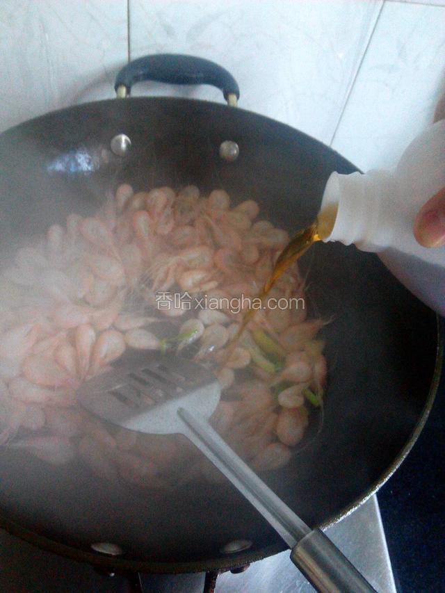 白米虾炒红倒入料酒