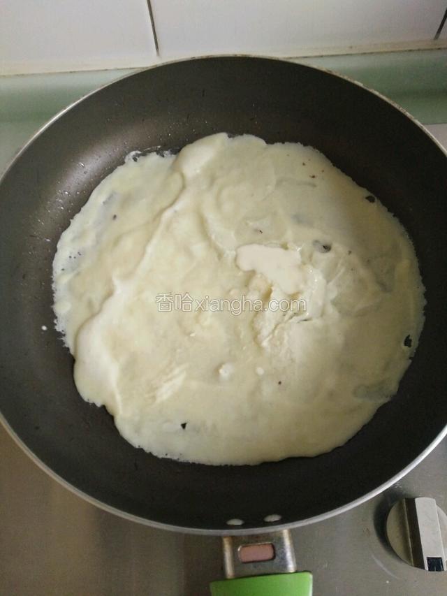 把和好的面糊摊入锅中
