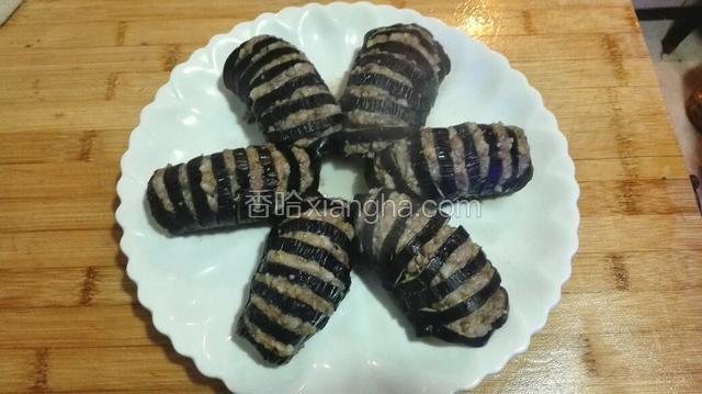 取出蒸好的茄子，倒出盘中的水