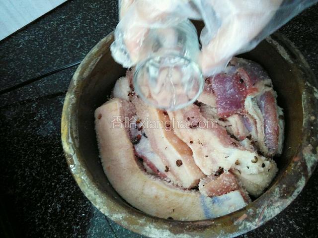 再倒一些白酒在肉上。如此反复，直到所有肉都放进缸里。