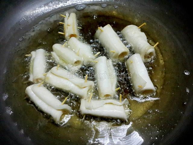 锅里下油烧至成七成热左右，把杏鲍菇卷放下去炸，其间要经常翻动菇卷，以免炸至颜色不均匀
