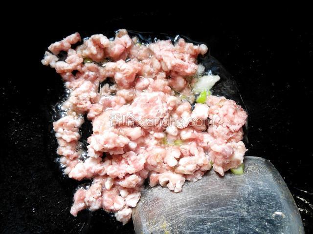 锅内放少许底油，葱花爆香，把肉末翻炒至变色。