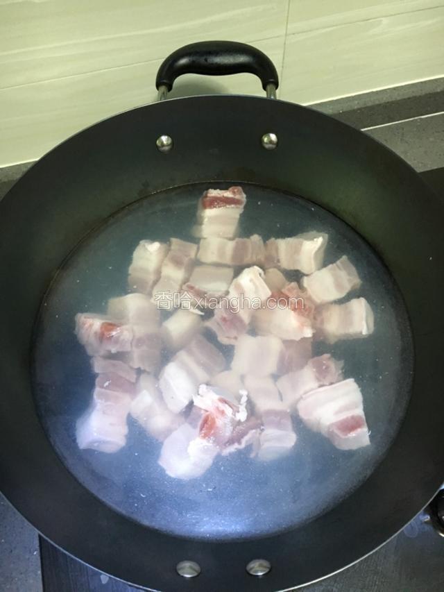 五花肉切成块，冷水下锅，水开后再煮十分钟，然后沥干水分备用。