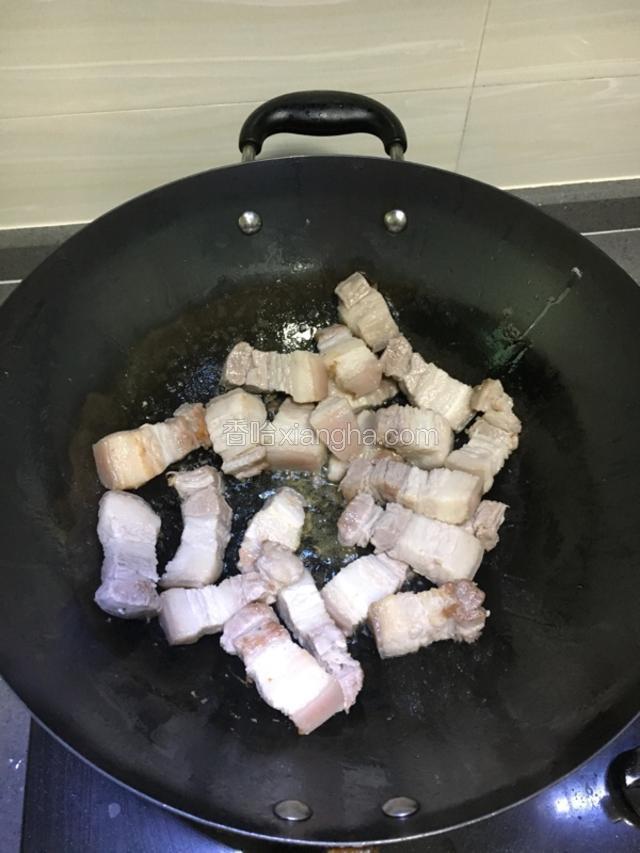 锅中倒入少许油，把沥干水份的五花肉，放入锅中翻炒出少许油份。
