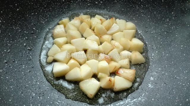 油烧热至八成，倒入苹果，进行炸与翻炒。