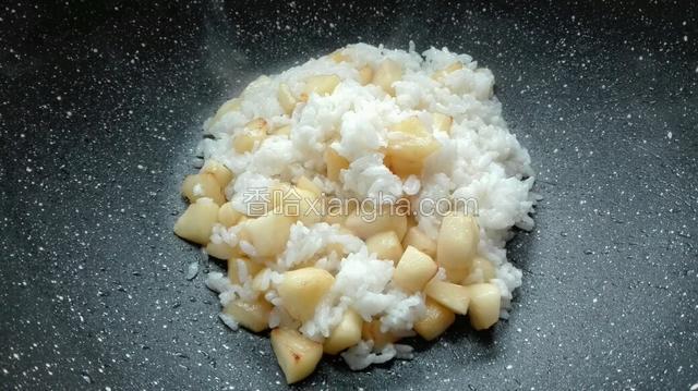 当苹果炸至浅黄色后，倒入米饭，一同翻炒。