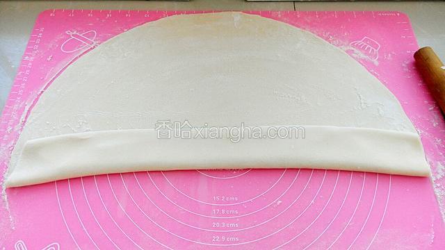 面皮上撒面粉，从一头开始叠起来。