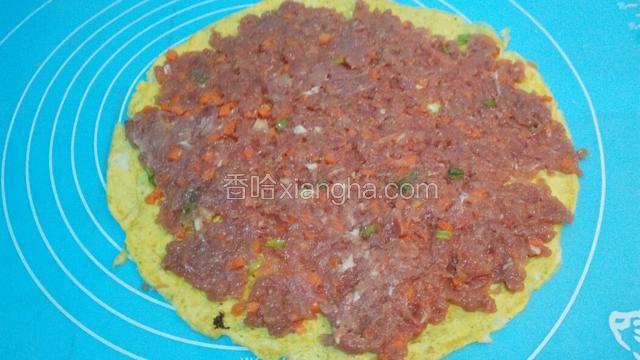把肉馅均匀地铺平在蛋皮上。