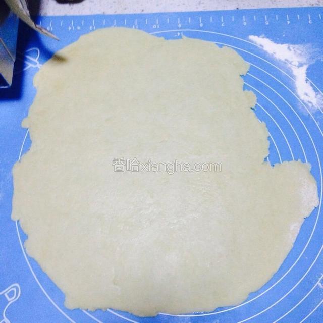 粘板上撒少许干面粉，用擀面杖把面团擀成薄饼状