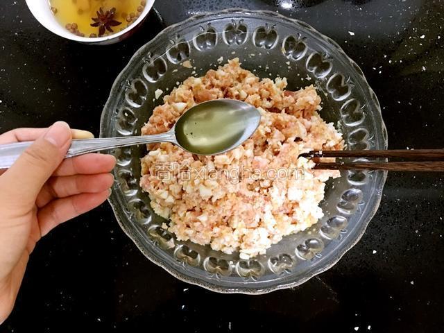 花椒水逐步加入肉馅搅拌。
