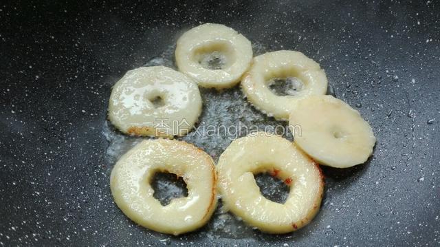 苹果圈一面炸至金黄色后，将其翻面。