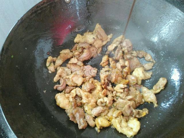 翻炒至肉片裹上油，微微变色。加一勺酱油，翻炒均匀。