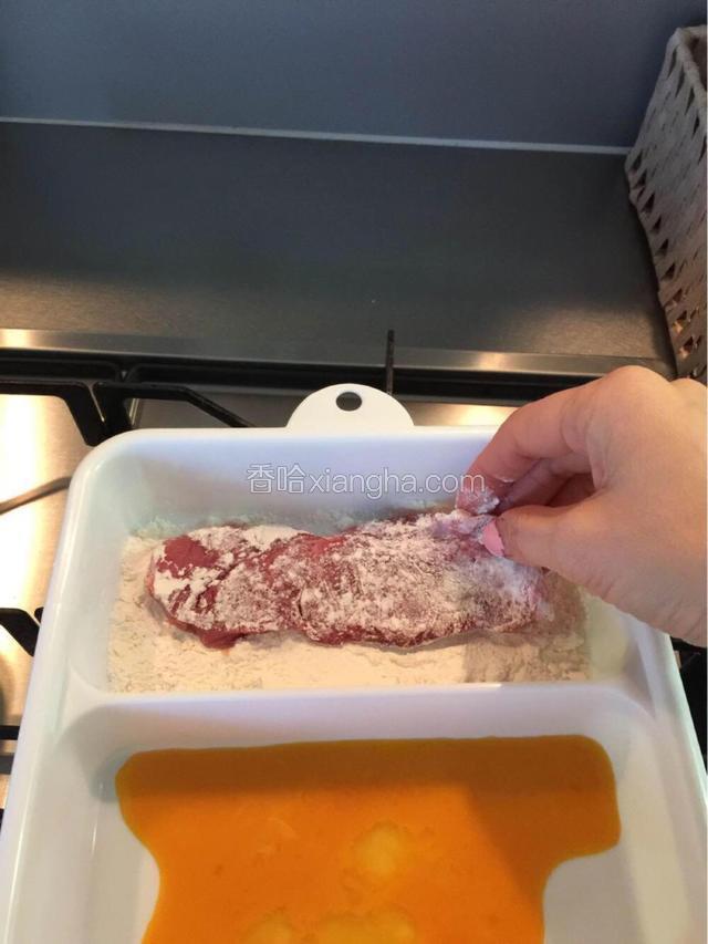 先把肉在面粉里滚过，两面都沾上薄薄的面粉