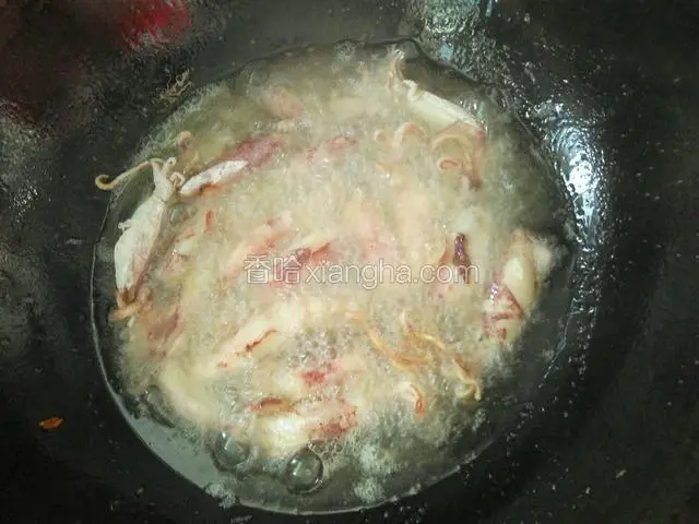 刚入油锅不要急着翻动鱿鱼仔，让它自己在油锅里炸一会。炸至鱿鱼仔表面微黄。