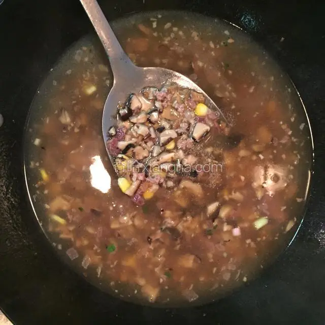 在酱汁烧开后加入肉末、腊肠丁、玉米粒、菜脯和爆炒过的香菇