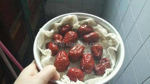 在模具中铺一层湿的屉布，然后一层糯米粉，一层红枣（粉+枣+粉+枣+粉）并压实