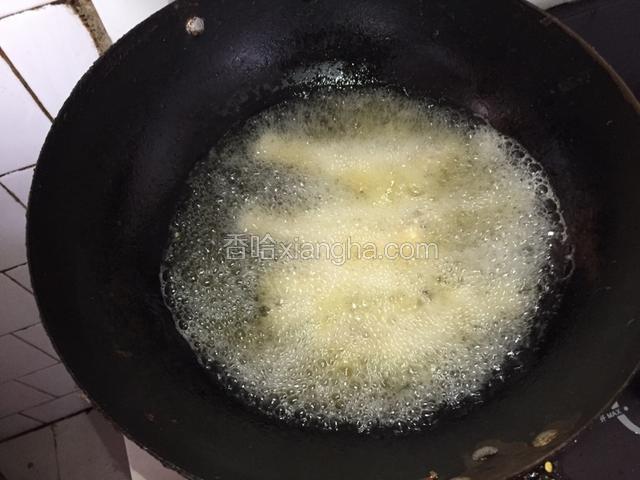 油热后，贴锅边把鱼下锅，中火开炸。