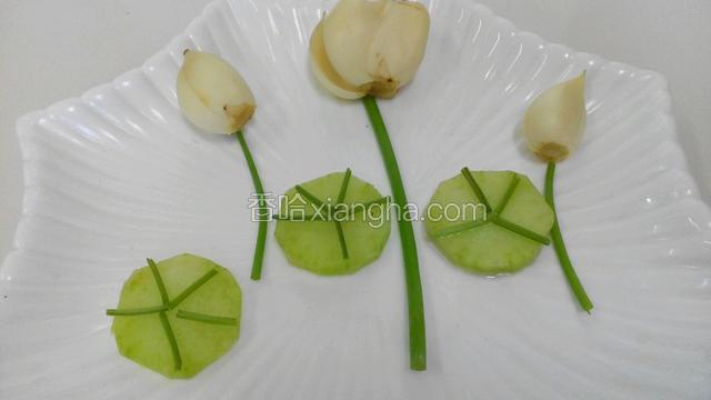 取小葱的用来做荷花的梗子，百合放在顶部，莴苣做的荷叶摆放好