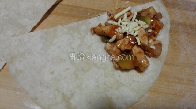 烙好的饼皮对半切开，在饼的一角放入炒好的鸡肉，撒些奶酪丝！
