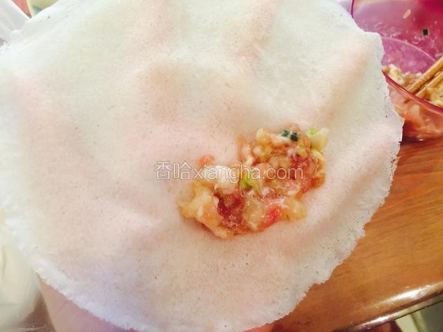 摊开春卷皮，将适量肉馅放置春卷皮下部，馅料不宜过多。