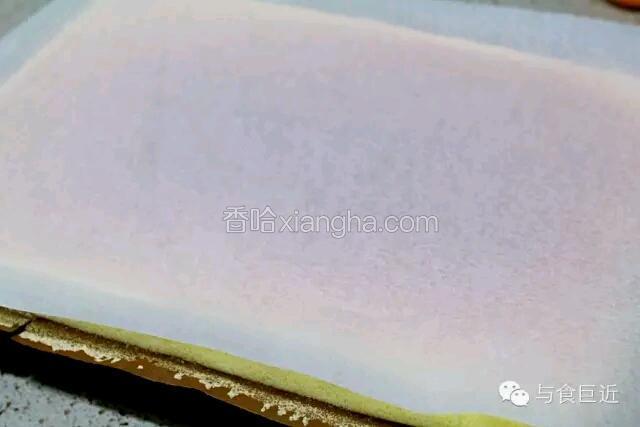 出炉震一下，立即将蛋糕连同烤纸移至烤架上。稍晾几分钟后在面上虚铺一张新的油纸。