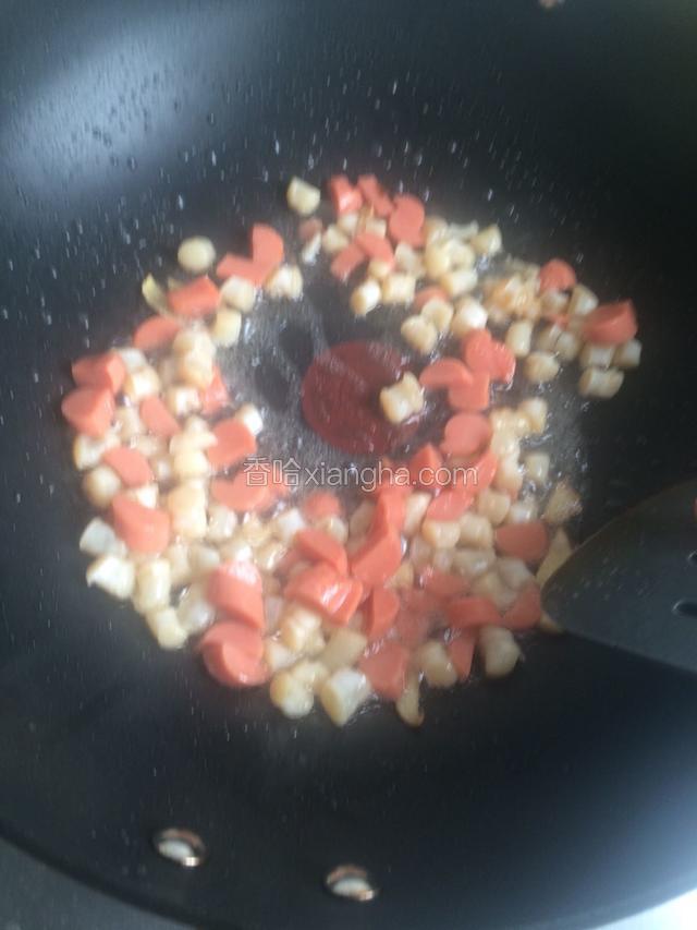 放入贝壳肉和香肠丁 炒几下