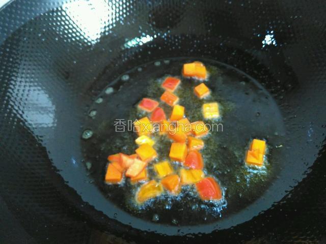 锅里油烧热，倒入胡萝卜和红椒炒匀