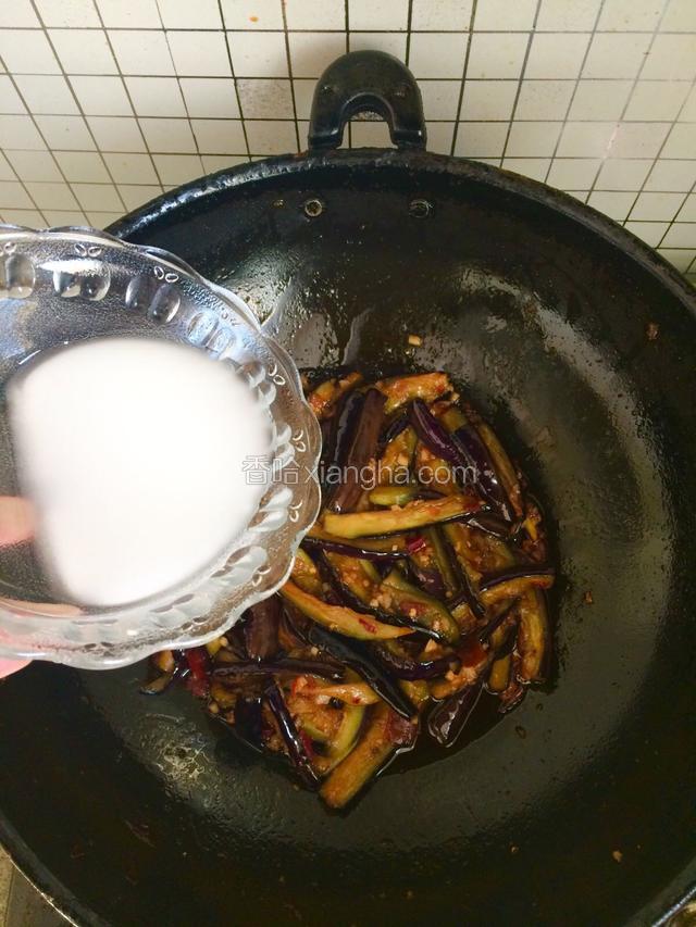 到茄条快熟时，转小火，倒入淀粉溶液快速翻炒挂汁，均匀收芡后即可出锅。