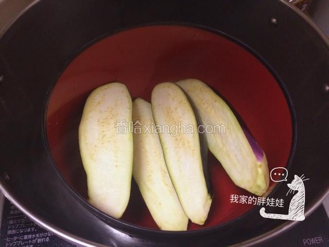 茄子切成两半，装碗入开水锅里蒸十分钟左右