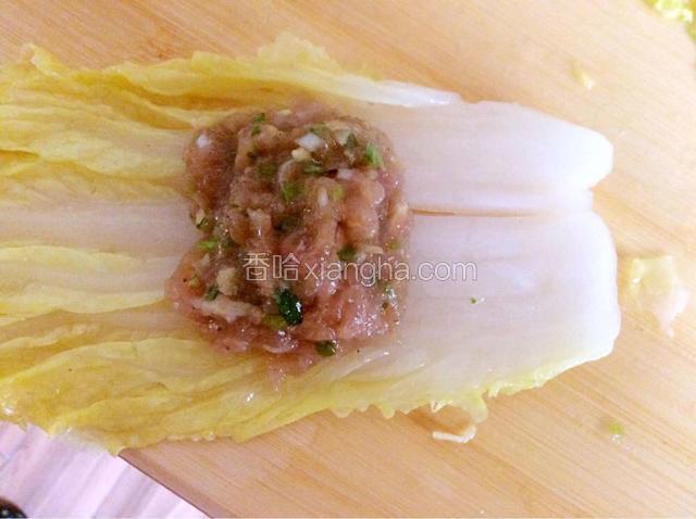 把肉馅放在白菜帮的中间部分，把帮往下一包即可。