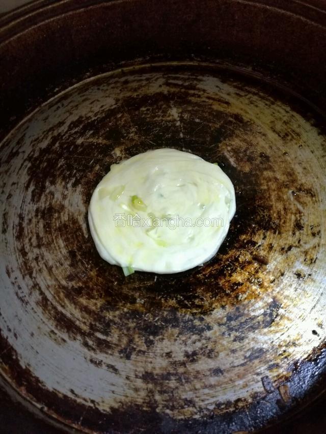 平底锅中小火预热，倒入适量的花生油，把面饼放入平底锅中，用锅铲压平面饼，两面煎。