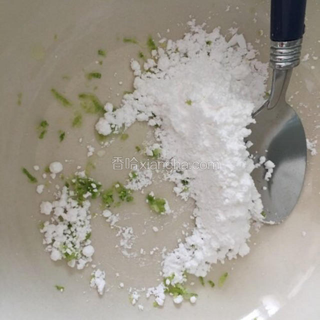把一点柠檬皮加入糖粉里。用汤匙按压让柠香融入糖粉里（ 这样做出来的蛋糕很清香哦)
