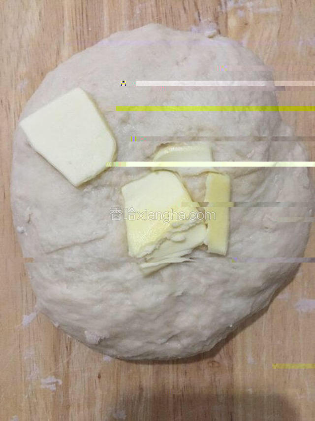 然后加入配方中的黄油，裹入面团中继续揉面。