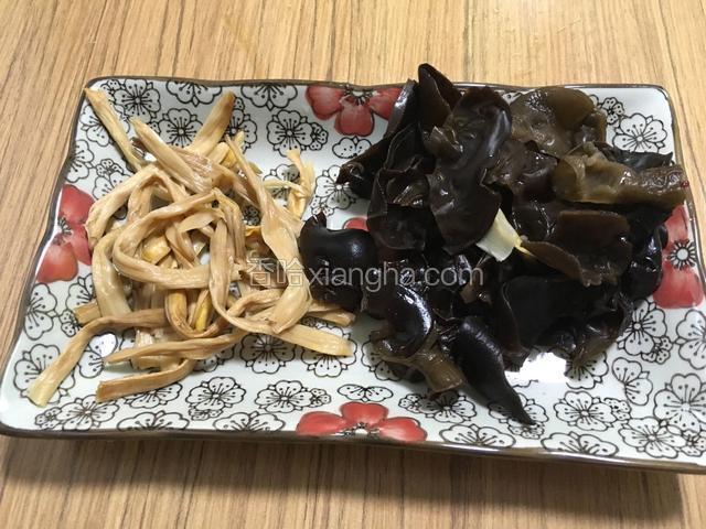 将浸泡后的黄花菜杆部去除，将木耳撕成小片，清洗干净备用