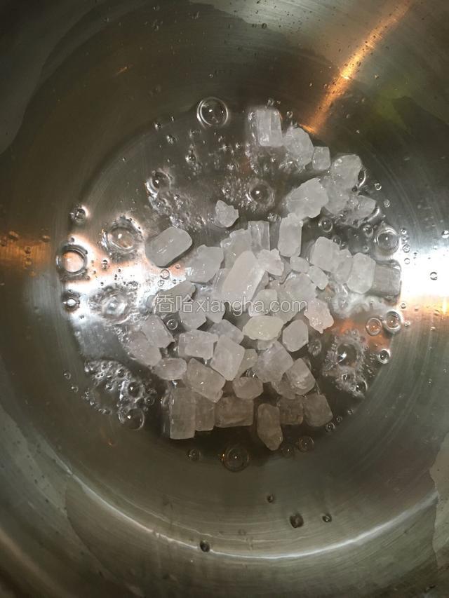 锅内倒入20ml清水并加入冰糖，将冰糖翻炒均匀融化