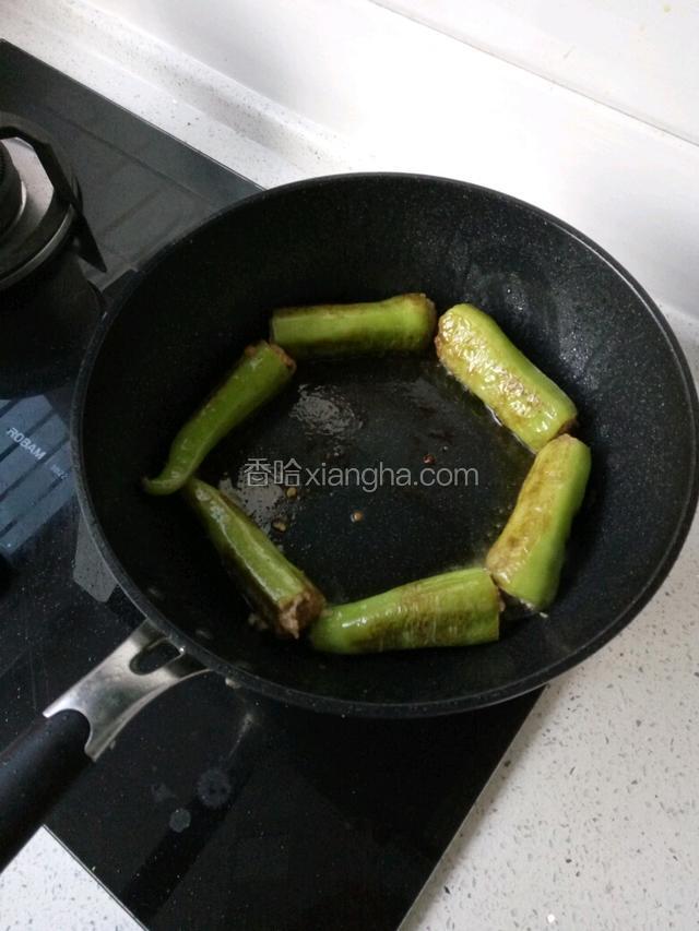 锅内加少许油，小火慢煎直至辣椒外表成虎皮状，肉馅熟透