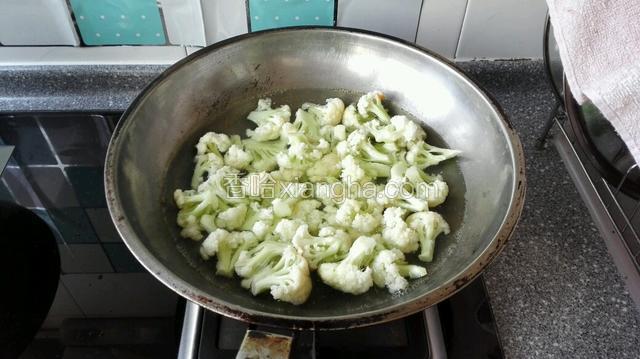 锅中放清水，水开后下入菜花焯水段生，捞岀过凉水备用