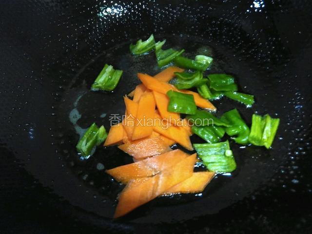 锅里油烧热，放入胡萝卜和青椒炒匀