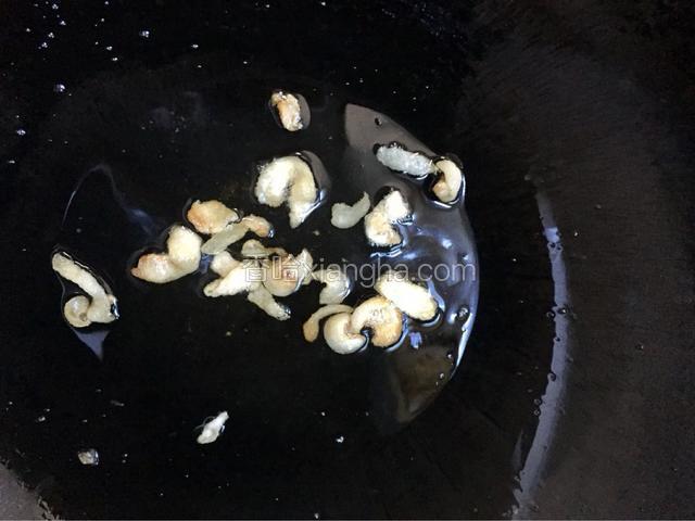 将锅中倒入少量的油，将肥肉倒入锅中小火翻炒，将油脂爆出
