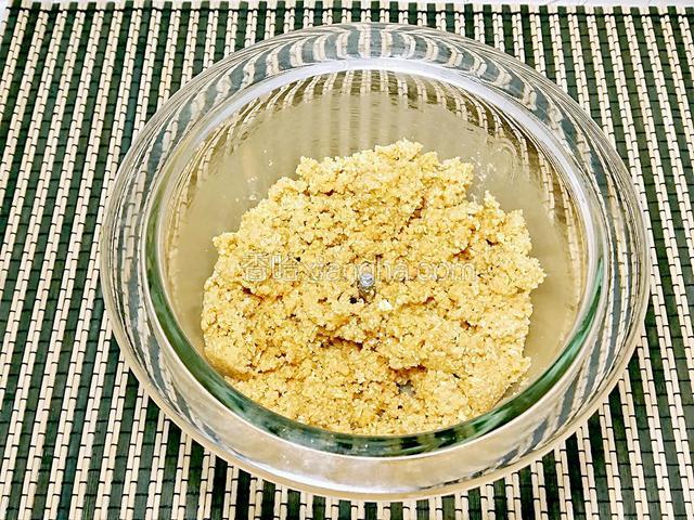 融化的黃油倒入消化餅裡用手抓勻