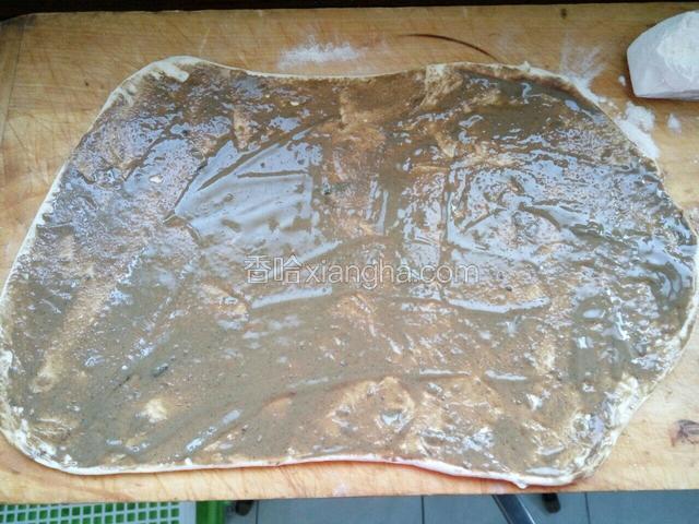 用擀面杖擀薄，抹匀一层厚厚芝麻酱