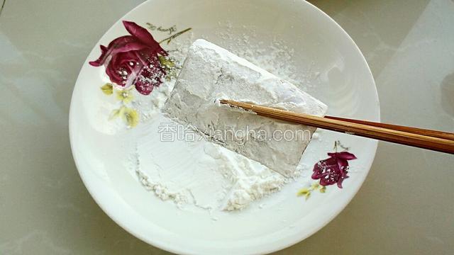 把腌制好的带鱼擦干多余水分，盘中放适量淀粉，把带鱼放进去两面薄薄地沾上一层淀粉。