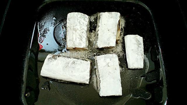 平底锅放适量油开小火，放入带鱼段煎制。