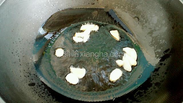 另起锅放适量油烧热后，放入切好的姜片和蒜片爆出香味。