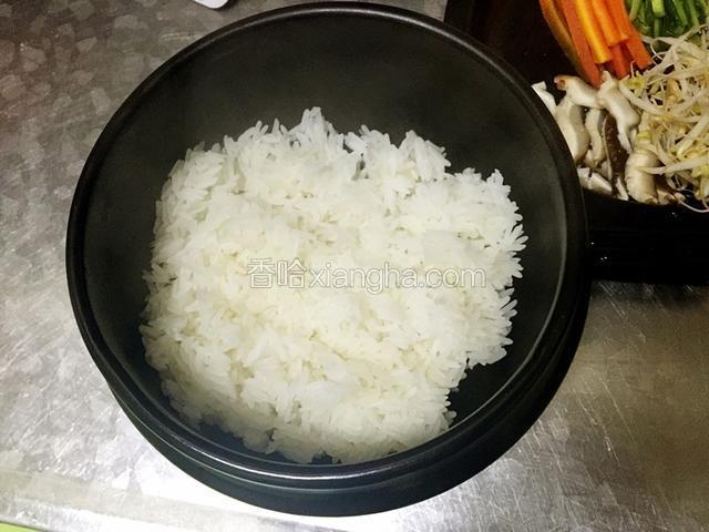 用香油在石锅底下抹一层，避免糊底，然后米饭装进去